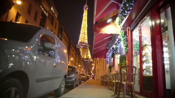 Jeune femme marchant vers la Tour Eiffel, passant un café décoré pour Noël — Video