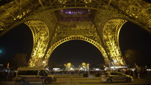 Muchos viajeros caminando por la Torre Eiffel en París por la noche, la policía de guardia — Vídeo de stock