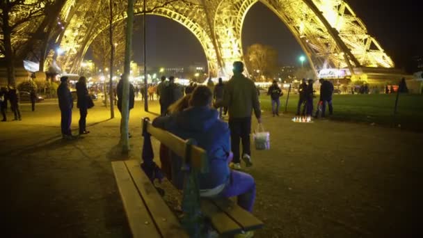 Hombre y mujer enamorados abrazándose en el banco de la Torre Eiffel, cita romántica — Vídeo de stock