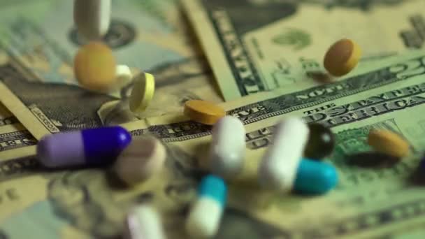 Colorful pills, tablets and capsules falling on US dollars, pharmacy business — Stock Video