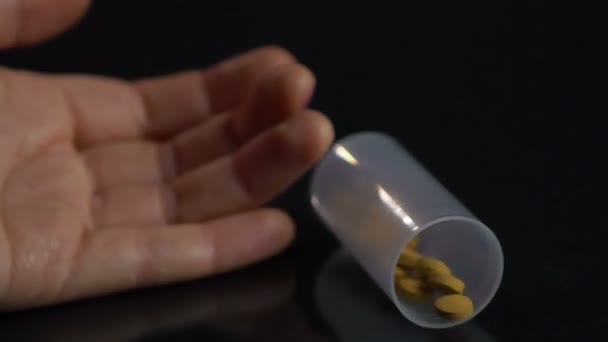 Hand van onbewuste persoon vallen op de vloer, morsen tabletten van pil fles — Stockvideo