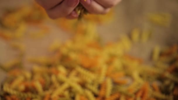 Красочные макароны в руках, ингредиент итальянской кухни, здоровый цельнозерновой продукт — стоковое видео