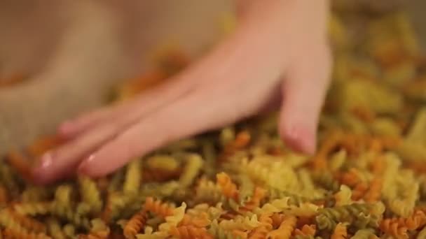 Mains expertes touchant des pâtes à grains entiers de couleur naturelle, vérifiant la qualité des aliments — Video