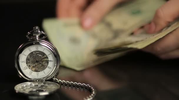 Pessoa contando notas de dólar, resumindo os resultados do investimento, relógio mostrando o tempo — Vídeo de Stock