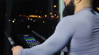 Sakallı adam spor olarak çalışma sonra gece cityscape pencereden bakarak