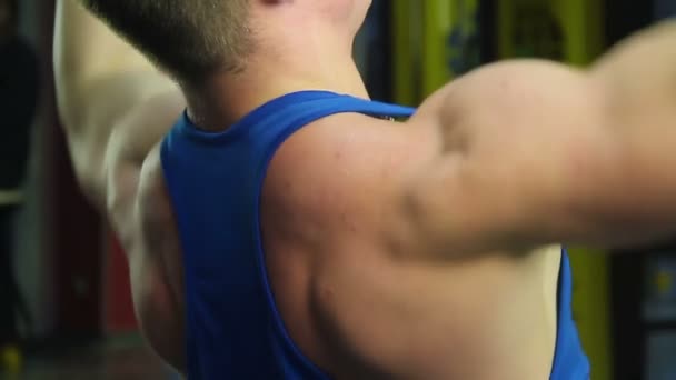Hombros tensos de hombre musculoso haciendo ejercicio de retirada, entrenamiento activo — Vídeo de stock