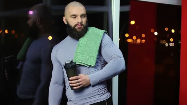 Hombre deportivo guapo descansando después de entrenar en el gimnasio, sonrisa en la cara, coquetear — Vídeos de Stock