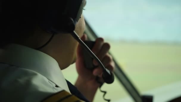 Happy pilot talking to controller, navigating airliner while moving on runway — Stock Video