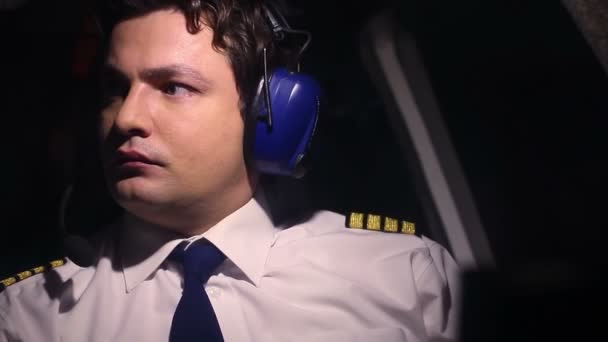 Serious professional pilot at work, checking flight indicators, talking to crew — Stock Video