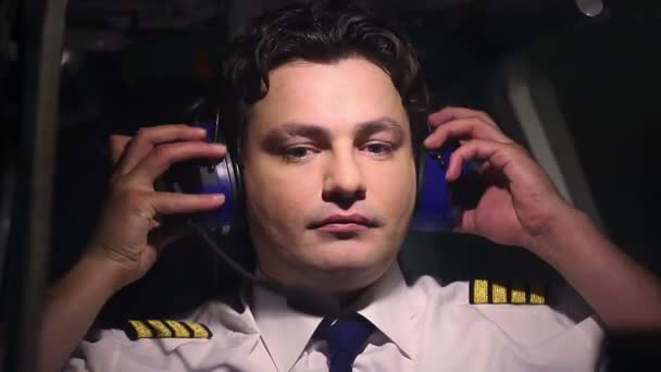 Piloto profesional en el trabajo, comunicándose con el controlador de vuelo usando auriculares — Vídeo de stock