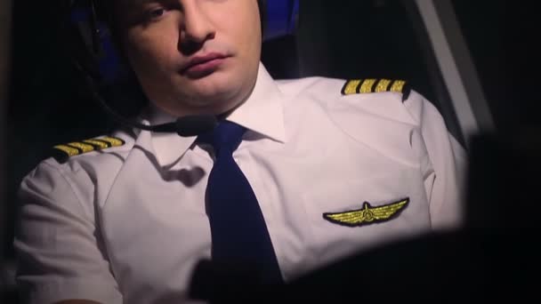 Seriöser männlicher Pilot in Zivilluftfahrt-Uniform blickt auf Flugkontrollpanel — Stockvideo