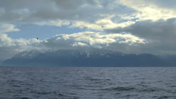 Tiempo tormentoso en los Alpes Suizos, nubes gruesas que cubren el cielo, salpicaduras de olas del lago — Vídeos de Stock