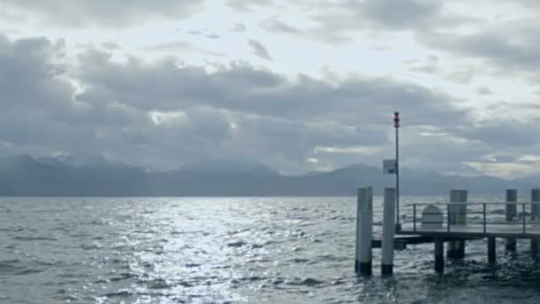 Paisaje triste, superficie áspera del agua, paisaje nublado tormentoso sobre montañas en el horizonte — Vídeos de Stock