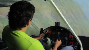 Genç adam uçuş simülatörü, gezinme direksiyon simidi, video oyunu manevra