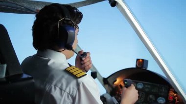 Erkek pilot radyo iletişim sistemini kullanarak hava trafik kontrolörü için konuşuyor
