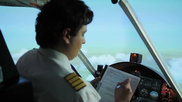 Seriöser Flugzeugführer beim Ausfüllen von Flugpapieren, Autopilot-Lenkflugzeug — Stockvideo