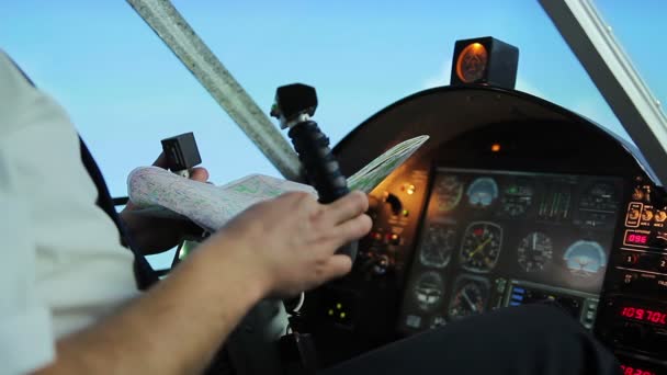 Pilot navigiert Flugzeug mit Lenkrad, überprüft Flugroute auf Karte — Stockvideo