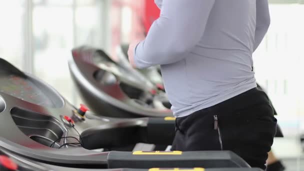 Mann joggt und geht auf Laufband, ändert Einstellungen, beendet Workout — Stockvideo