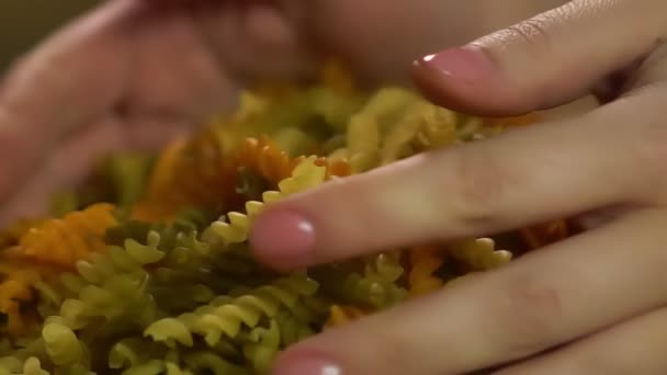 Housewife holding handful of colored raw pasta, healthy eco food production — Stock Video