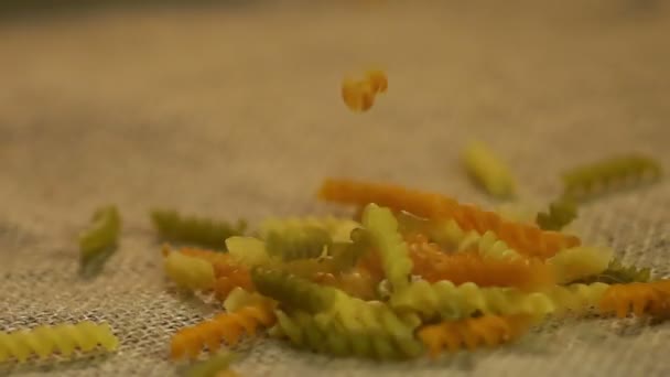 Trockene, farbige Pasta auf grauen Sack, Werbung für gesunde Nahrungsmittelproduktion — Stockvideo