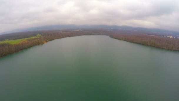 Aerial shot of autumn landscape, wide still river, gray clouds in sky on horizon — Stock Video