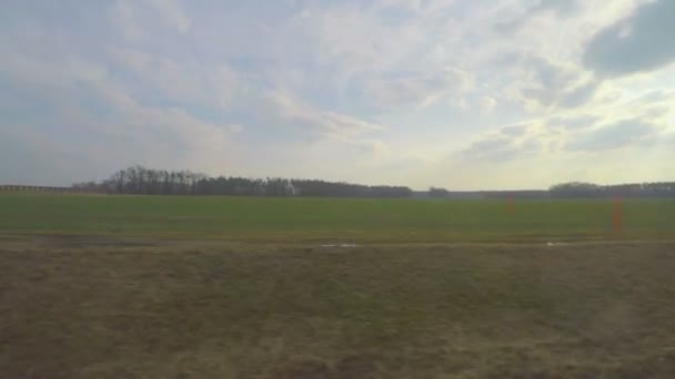 Train passing vast farming fields, plants, industrial area, view through window — Stock Video