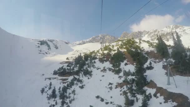 Vue en temps réel depuis une cabine de téléphérique se déplaçant sur des montagnes enneigées, sport extrême — Video