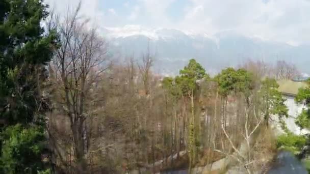 Bela vista aérea da cidade grande no fundo dos Alpes austríacos, neve nas montanhas — Vídeo de Stock