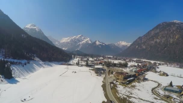 Зимний пейзаж, мирный курортный город в горах под голубым небом — стоковое видео