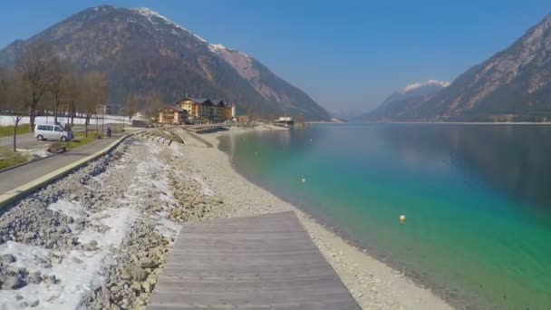 Повітряний дерев'яний пірс біля озера, снігові гори, творчий ефект швидкого руху — стокове відео