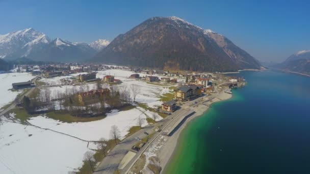 Vista aérea, resort popular em Alpes austríacos, montanhas majestosas, lago azul profundo — Vídeo de Stock