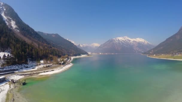 Панорама глибоководного озера на засніжених горах знизу, дзеркально-подібна водна поверхня — стокове відео