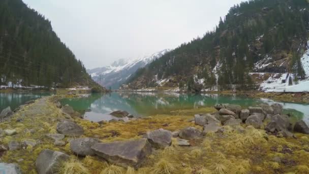 Bord de lac caillouteux en montagne, lignes électriques, production d'énergie alternative — Video