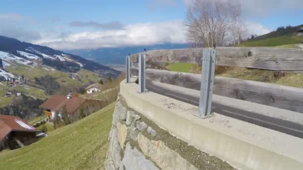 Serpentine weg in de hoge bergen, bewolkte hemel over groene hellingen, Alpine dorp — Stockvideo