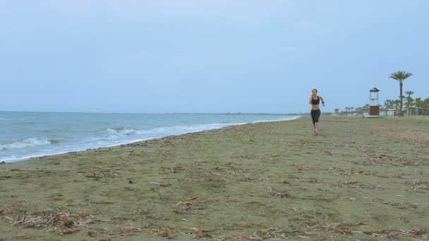 Female athlete training at seaside, running on sandy beach. Success motivation — Stock Video