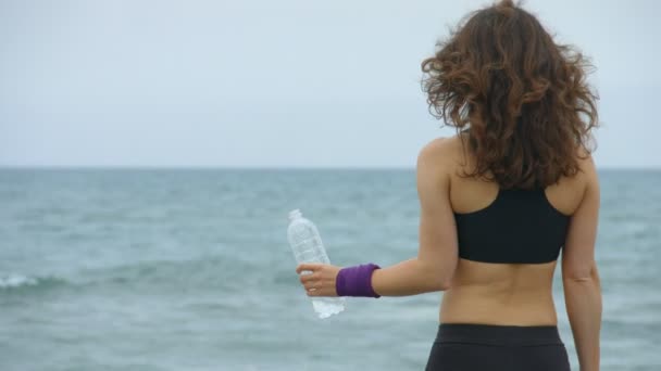 Joven deportista se siente sedienta después del entrenamiento, beber agua fresca de la botella — Vídeos de Stock