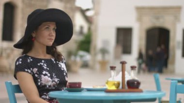 Güzel genç kadın açık zevk rahatla sokak kafe, birini bekliyor