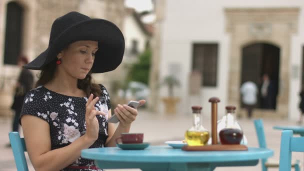 Felice giovane donna in caffè comporre il numero di telefono sul touch screen, chiamando un amico — Video Stock