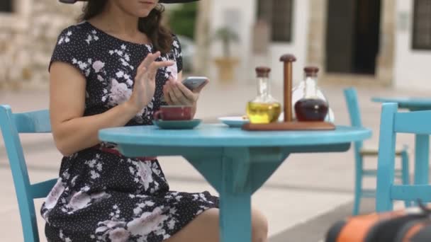 Vacker kvinnlig turist att skriva meddelande, chattar online på smart telefon i café — Stockvideo
