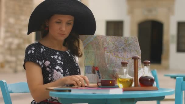 Ung dame undersøger kort, planlægningsrejse til sommerferie, søger seværdigheder – Stock-video