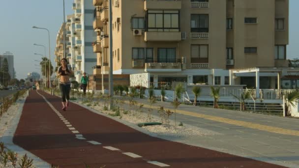 Attractive young woman doing morning run, taking care of her body and health — Stock Video