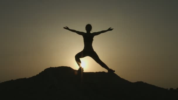 练习瑜伽时享受与大自然和谐相处的年轻女人的剪影 — 图库视频影像