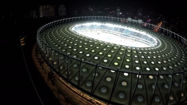 Kiev, Ukrayna - Yaklaşık Haziran 2016: Olimpiyskiy stadyumunun havadan görünümü. Parlak ışıklı modern stadyumda kalabalık tribünler, gece hava manzarası — Stok video