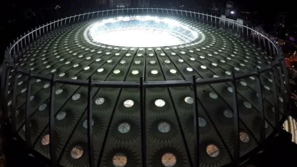 KYIV, UCRANIA - CIRCA JUNIO 2016: Vista aérea del estadio Olimpiyskiy. Techo masivo de gran estadio de fútbol iluminado por la noche, equipos jugando partido — Vídeos de Stock