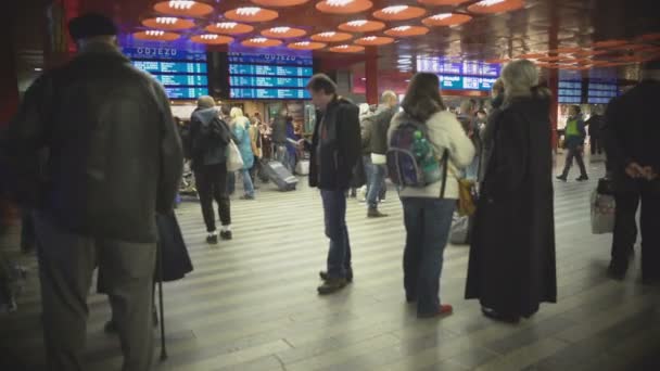 Praga, Czechy-Circa grudzień 2015: Pasażerowie na dworcu kolejowym. Tłum pasażerów oczekujących na dworcu kolejowym, sprawdzanie rozkłady jazdy pociągów — Wideo stockowe