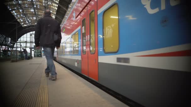 ПАШГУЕ, ЧЕШСКАЯ РЕСПУБЛИКА - CIRCA DECEM2015: Пассажиры на вокзале. Городской поезд покидает железнодорожную платформу, пассажир мужского пола не успевает на посадку вовремя — стоковое видео