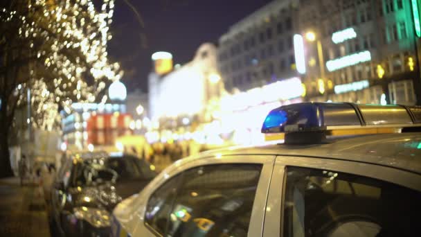 Coche de policía en el sitio de protesta masiva, oficial patrullando la calle de la ciudad llena de gente por la noche — Vídeos de Stock