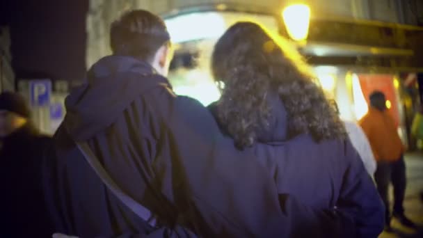 Νεαρός άντρας και γυναίκα περπατούν αγκαλιασμένοι, ζευγάρι ερωτευμένοι απολαμβάνοντας το χρόνο μαζί — Αρχείο Βίντεο