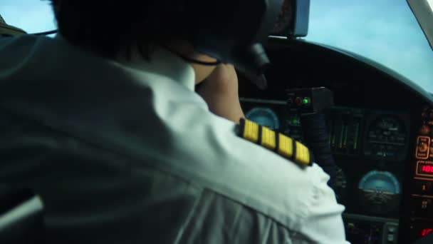 Manlig pilot kontrollera kontroll panel och rapportering situationen att flyg dispatcher — Stockvideo