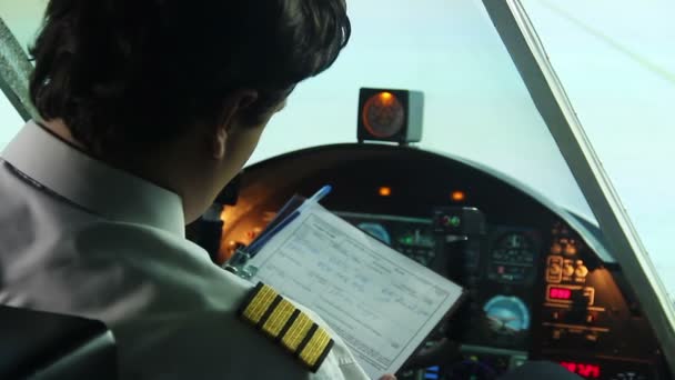 Літак, що стоїть на злітно-посадковій смузі, пілот заповнює документи та стартовий рейс — стокове відео